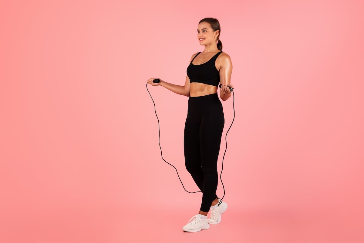 mulher pulando corda com roupas fitness